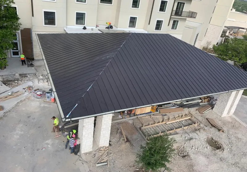 Metal roofing installation team working on a commercial building in Johnston